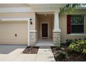 Inviting front entrance with stone accents and a covered porch leading to a wood door at 20945 Oldenburg Loop, Mount Dora, FL 32757
