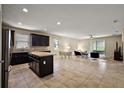 Bright, open-concept with kitchen island, tile flooring, and sliding doors to the lanai at 20945 Oldenburg Loop, Mount Dora, FL 32757