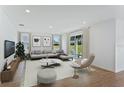 Bright living room with modern furnishings and a sliding glass door to the backyard at 2208 Keystone Pass Blvd, Minneola, FL 34715