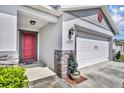 Welcoming front entrance with a red door, brick accents, and manicured landscaping at 2488 Begonia St, Mascotte, FL 34753