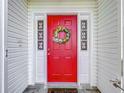 Close-up of the bright red front door adorned with a colorful wreath at 26338 Glen Eagle, Leesburg, FL 34748