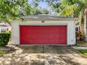 A close-up view of the home's white garage with a striking red door at 26338 Glen Eagle, Leesburg, FL 34748