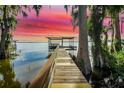 Picturesque dock with covered area and stunning lake views at sunset at 30523 Orange Dr, Leesburg, FL 34748