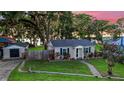 Charming home with manicured lawn, fenced yard, and detached garage at 30523 Orange Dr, Leesburg, FL 34748
