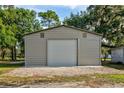 Large metal building garage with a roll-up door and ample storage space at 3359 County Road 513, Wildwood, FL 34785