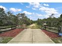 Long driveway with mature trees and ADT security system at 37007 Forestdel Dr, Eustis, FL 32736