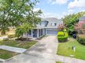Charming two-story home with a well-manicured lawn, red front door, and an attached two-car garage at 4445 Blue Major Dr, Windermere, FL 34786