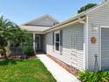 Landscaped front yard with walkway leading to the entrance of the light gray sided home at 4521 Eaglewood Dr, Leesburg, FL 34748