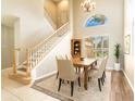 Charming dining area shows staircase, chandelier, neutral walls and furniture, complemented by modern vinyl flooring at 4548 Barrister Dr, Clermont, FL 34711