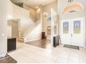 Grand foyer features soaring ceilings, a staircase, hardwood floors, and decorative front doors with leaded glass at 4548 Barrister Dr, Clermont, FL 34711