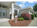 Inviting home entrance with a well-manicured garden and decorative accents at 4904 Long Meadow Dr, Leesburg, FL 34748
