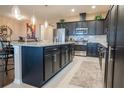 Open kitchen design with central island, dark cabinetry, stainless steel appliances and breakfast bar at 525 Narrow View Ln, Groveland, FL 34736