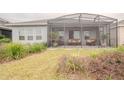 Outdoor patio with screened enclosure, multiple seating options and lush landscaping at 525 Narrow View Ln, Groveland, FL 34736