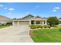 Inviting home featuring a well-maintained lawn, manicured landscaping, and neutral color palette at 5311 Eads Ter, The Villages, FL 32163