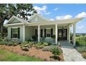 Inviting single-story home with a covered porch, lush garden beds, and a view of the water at 622 W 11Th Ave, Mount Dora, FL 32757