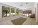 Bright sunroom featuring large windows with scenic views, tile floors, and elegant light fixtures at 7921 Sebago Ct, Orlando, FL 32835