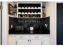 Stylish bar area features a wine rack, black backsplash, and cabinets for storage and serving at 999 W Juniata St, Clermont, FL 34711
