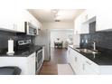 Modern kitchen with white cabinets, black countertops, stainless steel appliances and wood floors at 999 W Juniata St, Clermont, FL 34711