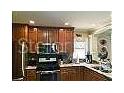 A kitchen with stainless steel appliances and plentiful wood cabinets, ready for cooking at 1041 Reidville Rd, The Villages, FL 32162