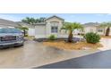 Charming single-story home featuring a well-manicured lawn, beautiful landscaping, and a two-car garage at 1065 Berg Ct, The Villages, FL 32162