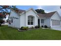 Charming home featuring a well-manicured lawn and flower beds with various plants at 1105 San Remo Ln, Lady Lake, FL 32159