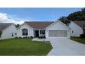 Charming home featuring a well-manicured lawn and a convenient two-car garage at 1105 San Remo Ln, Lady Lake, FL 32159