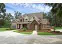 Beautiful two-story brick home with stone accents, lush landscaping, and a circular driveway at 1325 Otters View Ct, Fruitland Park, FL 34731