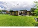 A spacious backyard featuring a covered patio and a well-maintained lawn at 1415 Braebury Dr, Leesburg, FL 34748