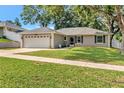 Lovely single-story home featuring a manicured lawn, shade trees, and a two-car garage at 1511 W Magnolia St, Clermont, FL 34711