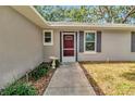 Close-up of front door with red trim and walkway and stone garden accents at 1511 W Magnolia St, Clermont, FL 34711