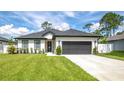 Beautiful single-story home featuring a lush green lawn, two-car garage, and modern architectural details at 1620 6Th Ave, Deland, FL 32724