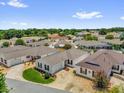 Aerial view showcasing a neighborhood of well-maintained homes with mature landscaping and clear blue skies at 17695 Se 84Th Peyton Ct, The Villages, FL 32162