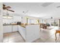 Open concept living space with tile flooring, white walls, and a ceiling fan, seamlessly connecting to the kitchen at 17695 Se 84Th Peyton Ct, The Villages, FL 32162