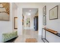 Bright foyer boasts high ceilings, neutral walls, tile flooring, and is decorated with modern art at 1990 Wallingford Loop, Mount Dora, FL 32757