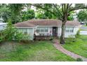 Charming single-story home with a brick pathway and beautiful lawn at 212 Blossom Ln, Winter Park, FL 32789
