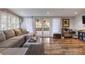 Inviting living room featuring a comfortable sectional sofa, hardwood floors, and french doors to the backyard at 212 Blossom Ln, Winter Park, FL 32789