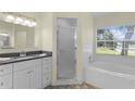 Bright bathroom with a granite countertop vanity, a bath tub, and tile flooring at 24954 Navel Ave, Leesburg, FL 34748