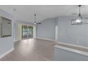 Spacious living room with gray walls, light hardwood floors, and views of the screened-in porch at 24954 Navel Ave, Leesburg, FL 34748