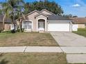 Inviting single-story home with a two-car garage and a well-maintained front yard at 2849 Doe Run Trl, Orange City, FL 32763