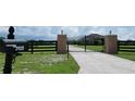 Gated entrance showing a manicured driveway leading to the home at 29222 Can Do Ln, Tavares, FL 32778