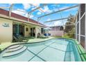 Inviting pool with sun loungers, table and chairs in a screened-in patio for relaxation and entertainment at 3016 Bloomsbury Dr, Kissimmee, FL 34747