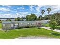 Charming home with a carport, lush landscaping, and a metal roof, near a tranquil lake at 31636 Gladys Ln, Tavares, FL 32778