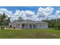 Spacious backyard showcasing the expansive lawn and screened patio for outdoor enjoyment at 32025 Timberlake Dr, Mount Dora, FL 32757