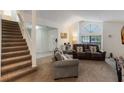 Spacious living room showcasing a staircase, neutral carpet, and comfortable seating arrangement at 3904 Valencia Grove Ln, Orlando, FL 32817