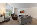 Bright living room featuring neutral carpet, a large window, and comfortable seating arrangement at 3904 Valencia Grove Ln, Orlando, FL 32817