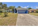 Inviting single-story home with a gray two-car garage and well-kept lawn at 428 Coventry Estates Blvd, Deltona, FL 32725