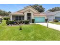 Inviting single-story home with a well-kept lawn and vibrant blue garage door at 4520 Eaglewood Dr, Leesburg, FL 34748