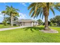 Well-maintained home with mature palm trees, a driveway, and a two-car garage at 5620 Illumination Ln, Leesburg, FL 34748