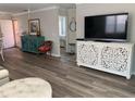 Bright living room featuring modern decor, wood-look flooring, and a decorative console at 627 Nuevo Leon Ln, The Villages, FL 32159