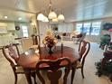 Cozy dining area with a round wooden table, seating for four, and an open view to the living room at 117 Jacaranda Dr, Leesburg, FL 34748